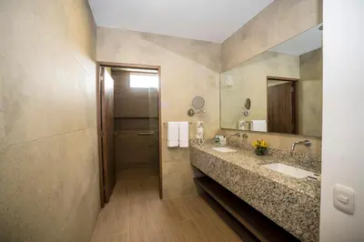 a bathroom with two sinks and a large mirror at Hotel Las Dunas in Ica