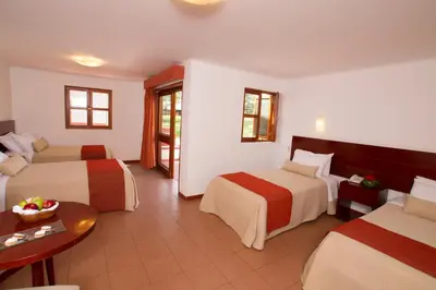 a hotel room with two beds and a table at Hotel Las Dunas in Ica
