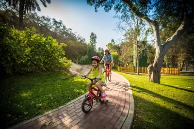a young girl riding a bike on a brick path at Hotel Las Dunas in Ica