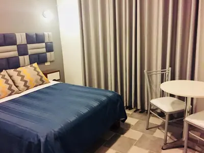 a bedroom with a bed and a table and a chair at Hostal Patiño in Lima