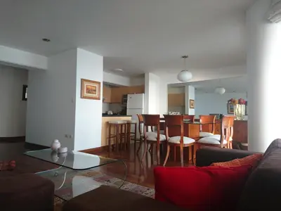 a living room and kitchen with a table and chairs at Malecón in Lima