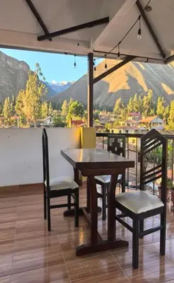 a table and chairs with a view of a mountain at Hotel Quilla in Urubamba
