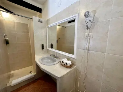 a bathroom with a sink and a shower with a mirror at Hatun Inti Classic in Machu Picchu