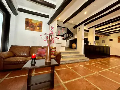 a living room with a couch and a table with a candle at Hatun Inti Classic in Machu Picchu