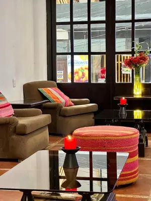 a living room with couches and tables and a candle at Hatun Inti Classic in Machu Picchu