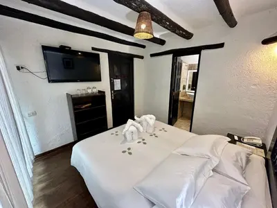 a bedroom with a white bed with towels on it at Hatun Inti Classic in Machu Picchu
