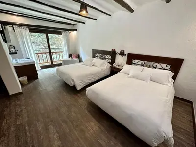 a hotel room with two beds and a window at Hatun Inti Boutique in Machu Picchu