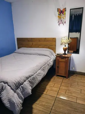 a bedroom with a bed and a table with a lamp at Habitación con baño privado acceso a cocina y terraza en Miraflores in Lima