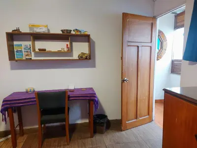 a table and a chair in a room with a mirror at Habitación con baño privado acceso a cocina y terraza en Miraflores in Lima