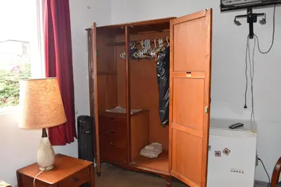 a closet with a wooden cabinet and a lamp at Habitación con dos camas, baño privado, terraza y cocina compartida en Miraflores in Lima