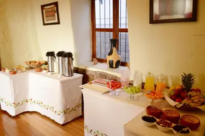 a room with two tables with food on them at Unaytambo Boutique Hotel Cusco in Cusco