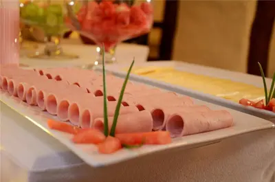 a plate of ham and carrots on a table at Unaytambo Boutique Hotel Cusco in Cusco