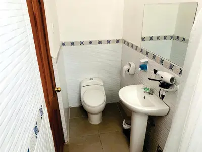 a small bathroom with a toilet and a sink at Inka Khawarina Tambo Lodge in Ollantaytambo