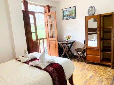 a bedroom with a bed with white towels on it at Inka Khawarina Tambo Lodge in Ollantaytambo