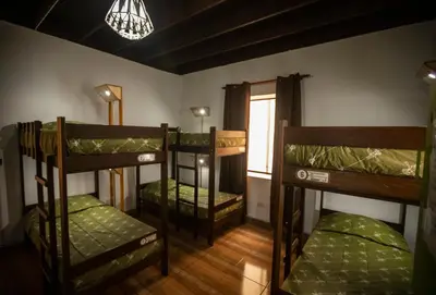 a room with three bunk beds and a window at Great Partners hostel in Lima