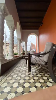 a porch with a chair and a tiled floor at Great Partners hostel in Lima