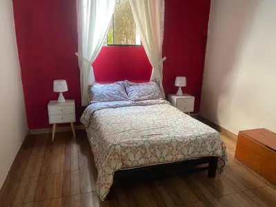 a bedroom with a bed with a red wall at Great Partners hostel in Lima
