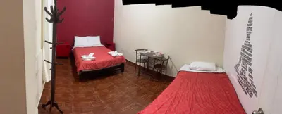 a room with two beds and a red and white wall at Great Partners hostel in Lima
