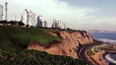 a city on top of a cliff next to the ocean at Apart Hotel Caminos del Inca in Lima