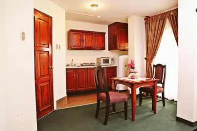 a kitchen with a table and chairs and a kitchen with a table and a kitchen at Apart Hotel Caminos del Inca in Lima