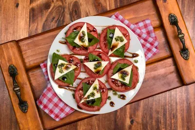 a plate of food with tomatoes and green peppers at KACLLA, The Healing Dog Hostel in Lima