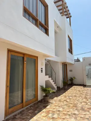 a white house with wooden doors and stairs at Betania in Paracas