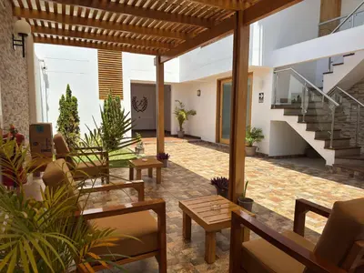 an outdoor patio with tables and chairs and stairs at Betania in Paracas