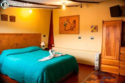 a bedroom with a bed with a stuffed animal on it at Hostal Teatro Inka in Cusco