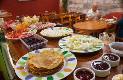 a wooden table with plates of food on it at Hostal Teatro Inka in Cusco