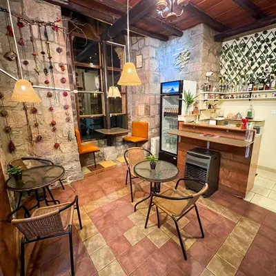 a room with tables and chairs and a stove at Hostal Teatro Inka in Cusco