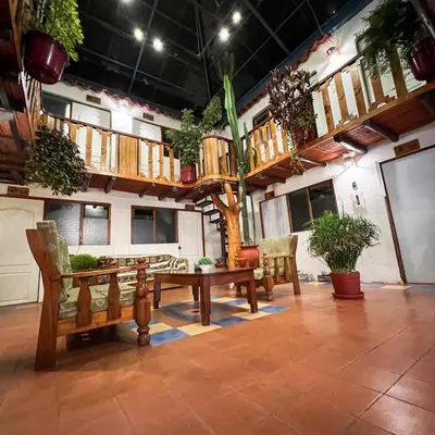 a room with a tree and a table and chairs at Hostal Teatro Inka in Cusco