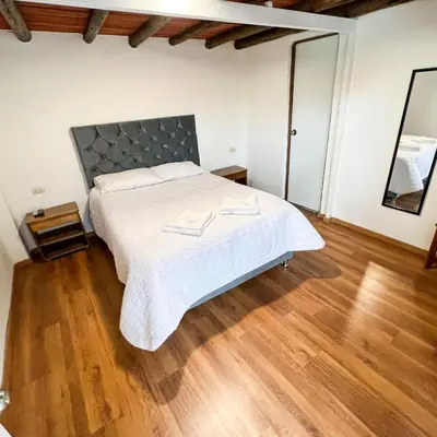 a bedroom with a large bed and a wooden floor at Hostal Teatro Inka in Cusco