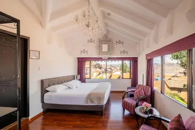 a bedroom with a bed and a chandelier at Tika Wasi Casa Boutique in Cusco