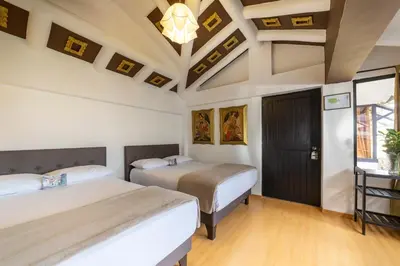 two beds in a room with a coffered ceiling at Tika Wasi Casa Boutique in Cusco