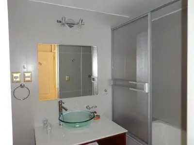 a bathroom with a sink with a mirror and a shower at Hotel Taypikala Machupicchu in Machu Picchu