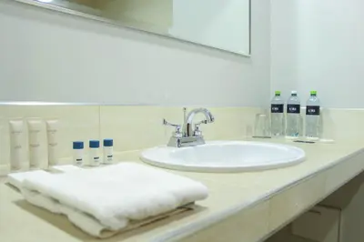 a bathroom counter with a sink and a mirror at Hotel Unu in Huancayo
