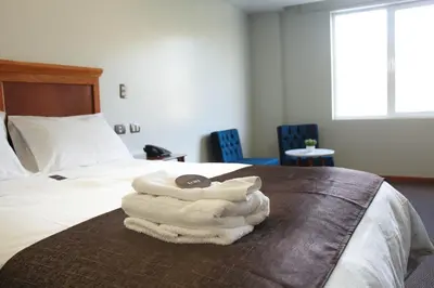 a pile of towels sitting on top of a bed at Hotel Unu in Huancayo