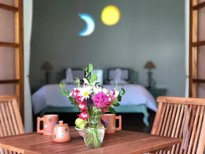 a vase of flowers sitting on a wooden table at Las Casitas del Arco Iris in Urubamba