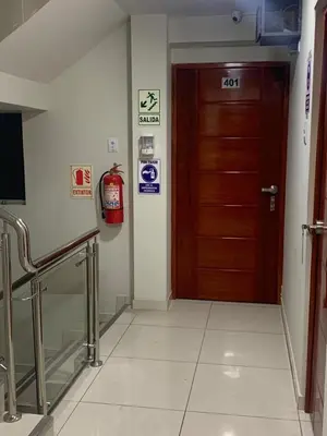 a hallway with a door and a fire extinguisher at A-Hope Suite Hotel in Huancayo