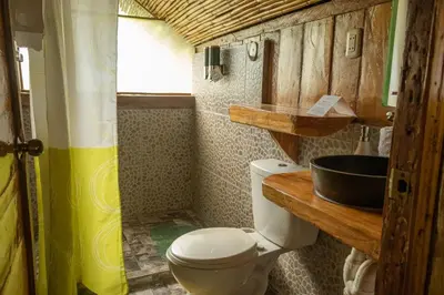 a small bathroom with a toilet and a sink at Eco Quechua Lodge in Santa Teresa