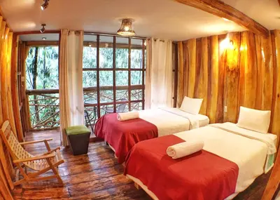 a hotel room with two beds and a window at Eco Quechua Lodge in Santa Teresa