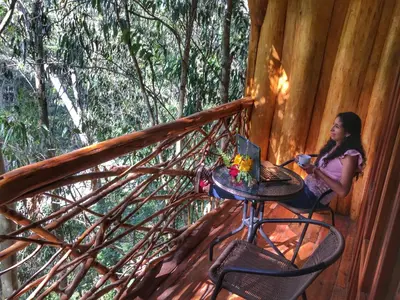 a woman sitting at a table on a porch at Eco Quechua Lodge in Santa Teresa