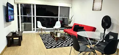 a living room with a red couch and a table at GL Apts, rent Upper Pardo Miraflores - Suite 1 Hab in Lima