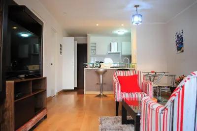 a living room with two chairs and a kitchen at GL Apts, rent Upper Pardo Miraflores - Suite 1 Hab in Lima