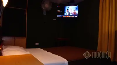 a bedroom with a bed and a tv on a wall at Hostal Residencial Mochica in Lima