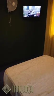 a bedroom with a bed and a tv on a wall at Hostal Residencial Mochica in Lima
