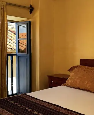 a bedroom with a bed and an open door at Huascaran Casa Boutique San Blas in Cusco