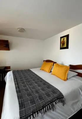 a bedroom with a large bed with yellow pillows at Huascaran Casa Boutique San Blas in Cusco