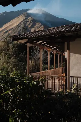 a house with a mountain in the background at El Albergue Ollantaytambo in Ollantaytambo
