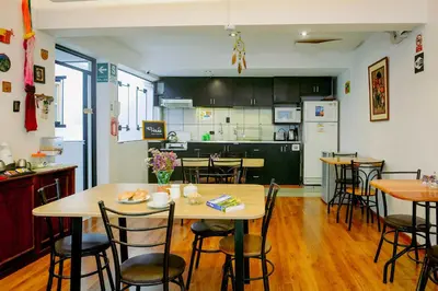 a kitchen and dining room with wooden tables and chairs at Net House Cusco in Cusco